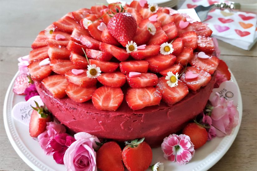 aardbeientaart, versierd met eetbare bloemen, voor mama
