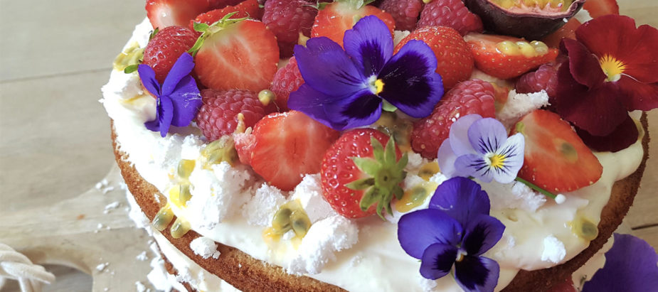 prachtig gestapelde eton mess taart met vers fruit en eetbare viooltjes