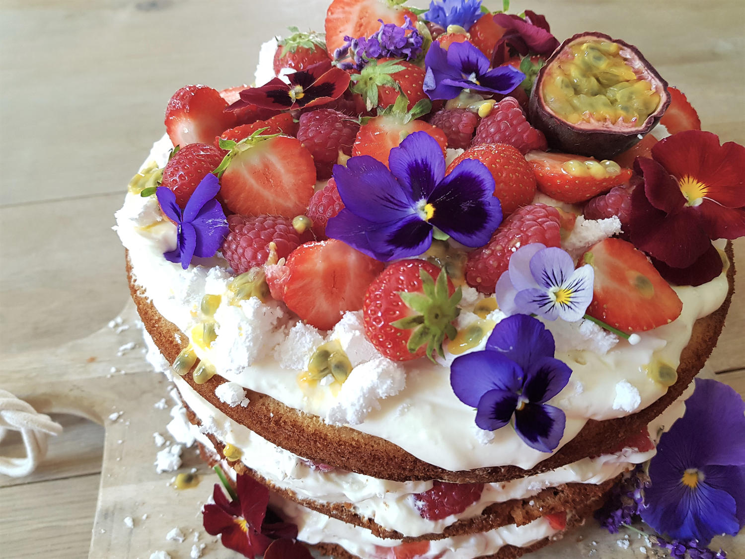 prachtig gestapelde eton mess taart met vers fruit en eetbare viooltjes