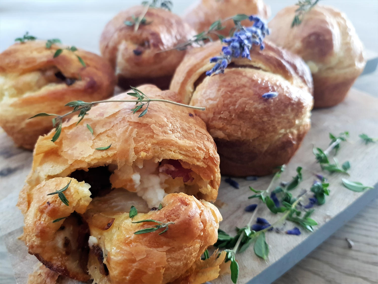 warme bladerdeegbroodjes met een vulling van geitenkaas, gekarameliseerde ui, spek en tijm
