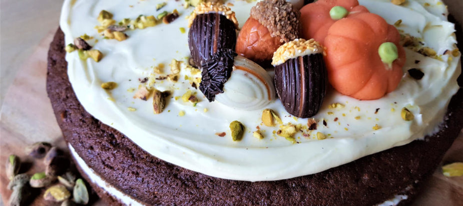 heerlijke pompoentaart met pistache en wortel (carrotcake), met mooie herfstdecoratie van chocolade eikels en marsepein pompoentjes